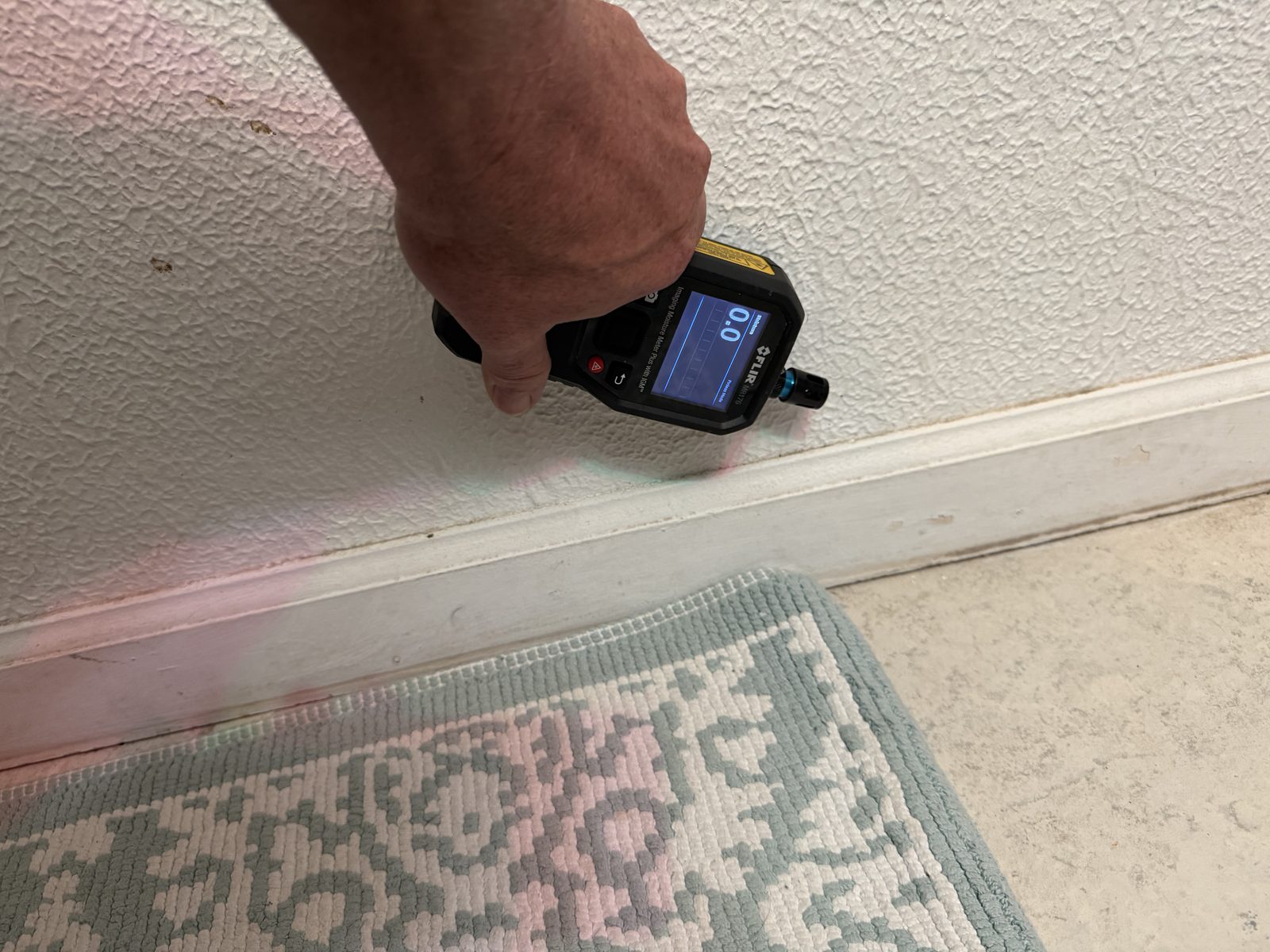 Moisture meter reading taken at the base of a wall