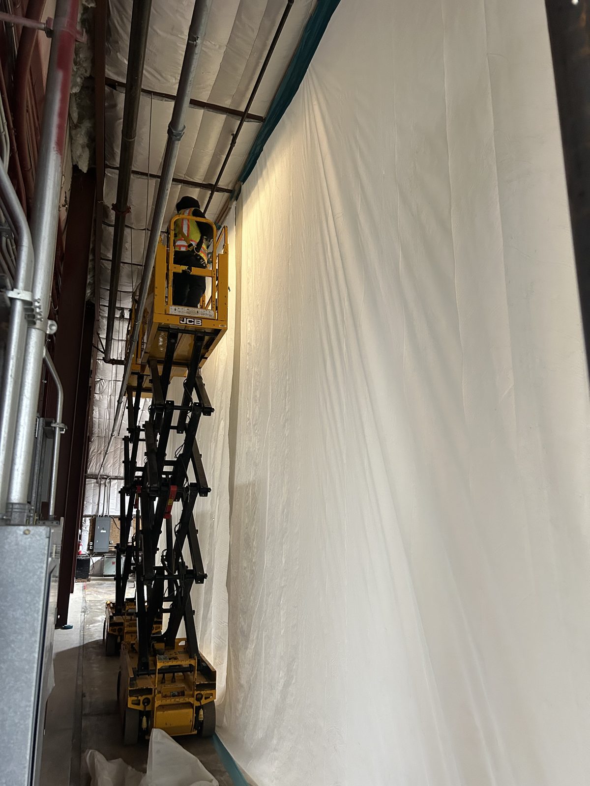 Containment wall built floor to deck inside an occupied warehouse