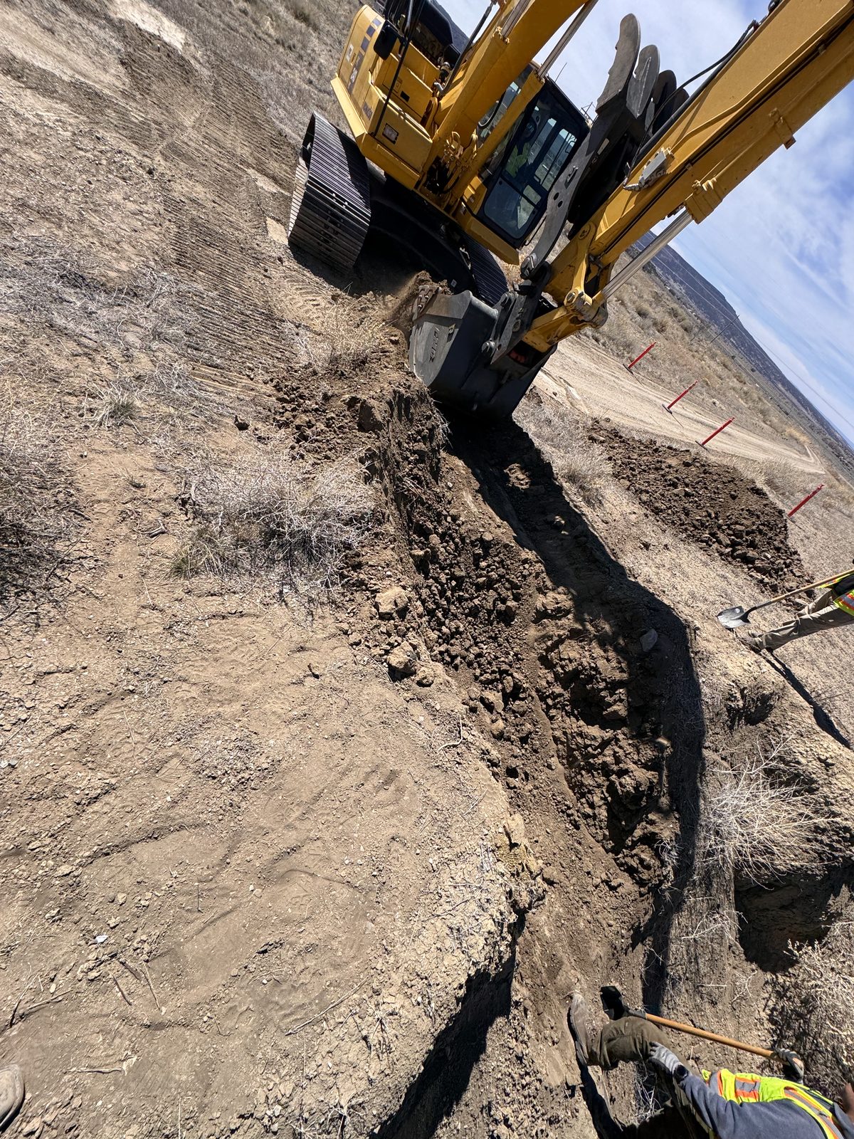 Excavator opening the trench over a buried asbestos cement line