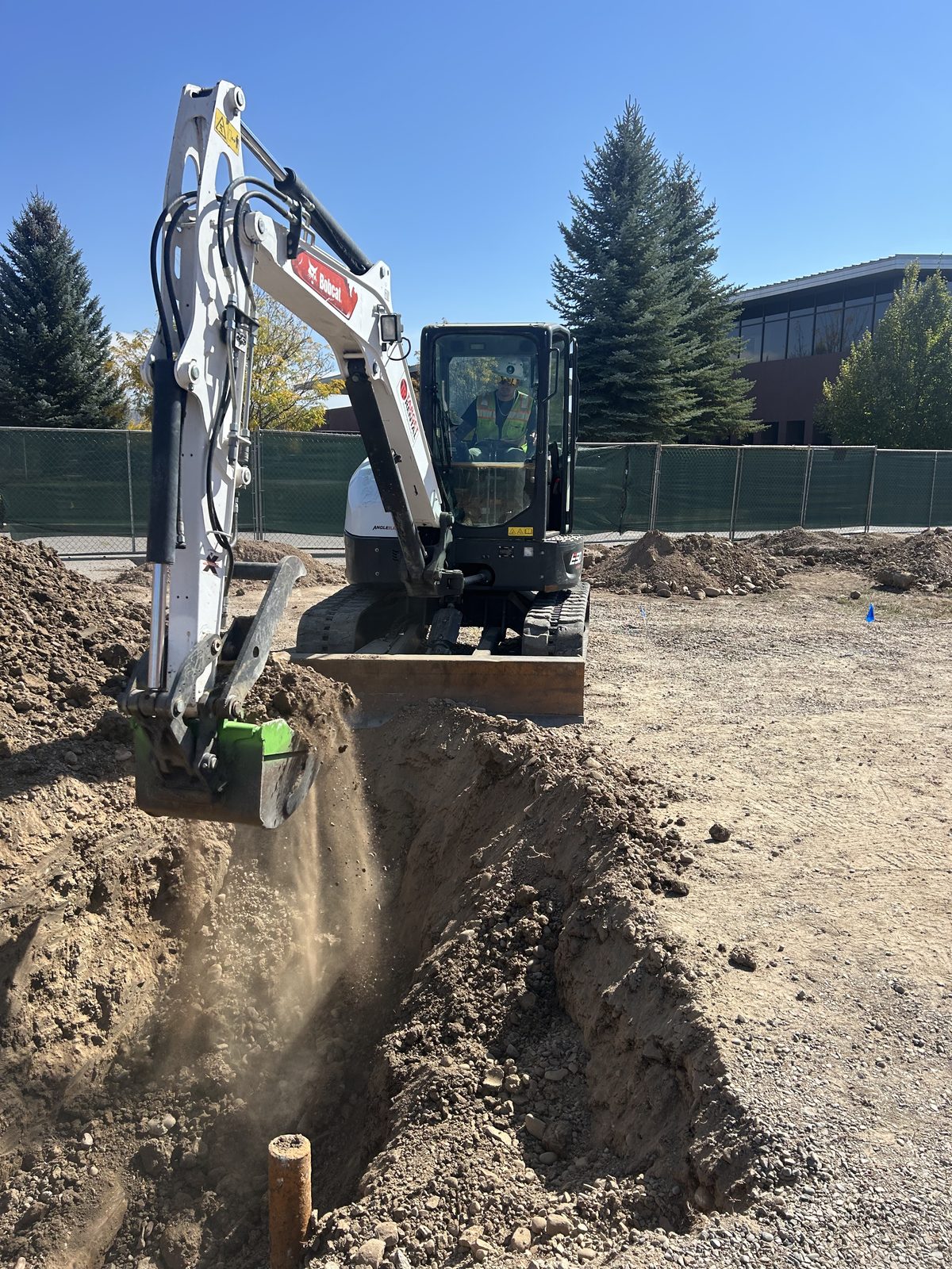 Excavator working a utility cut